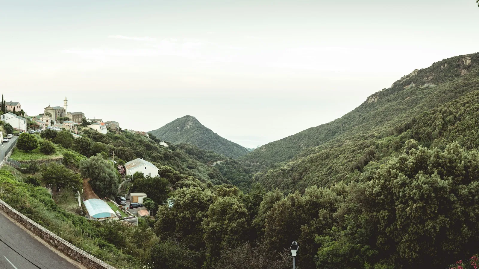 Route de montagne sinueuse en Corse traversée par une voiture électrique